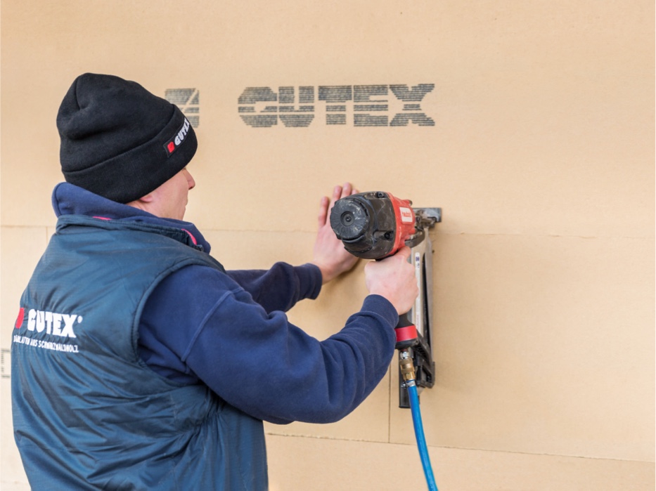 Mann macht Thermowall Dämmstoff von GUTEX fest | Holz-Hauff in Leingarten