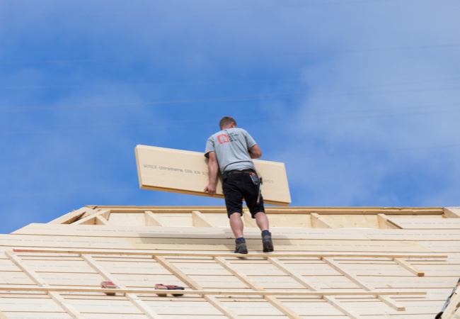 Dämmstoffe: Mann dämmt das Dach | Holz-Hauff in Leingarten