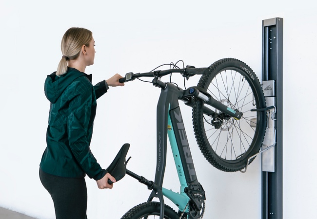Frau bringt ihr Fahrrad am BikeLikt an der Wand an | Gartenordnung | Holz-Hauff in Leingarten